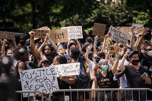 Protesters rally for justice and equality, displaying powerful signs in a city street.